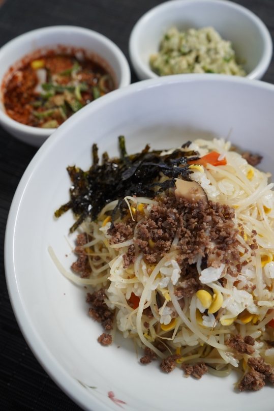 콩나물밥 한 그릇 — 다진 고기 고명과 김, 뒤로 양념장 두 가지